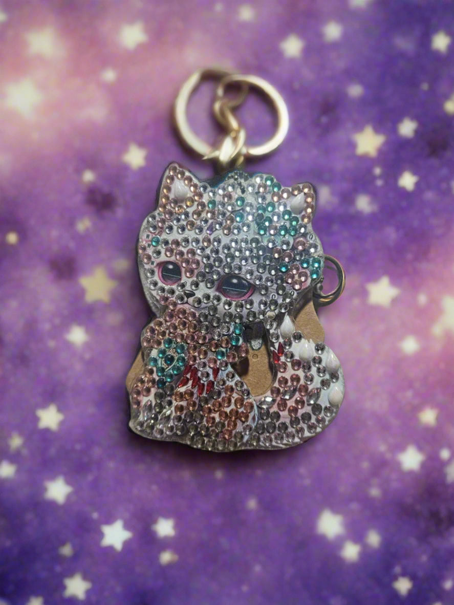 Decorative keychain with colorful beads on a light fabric background