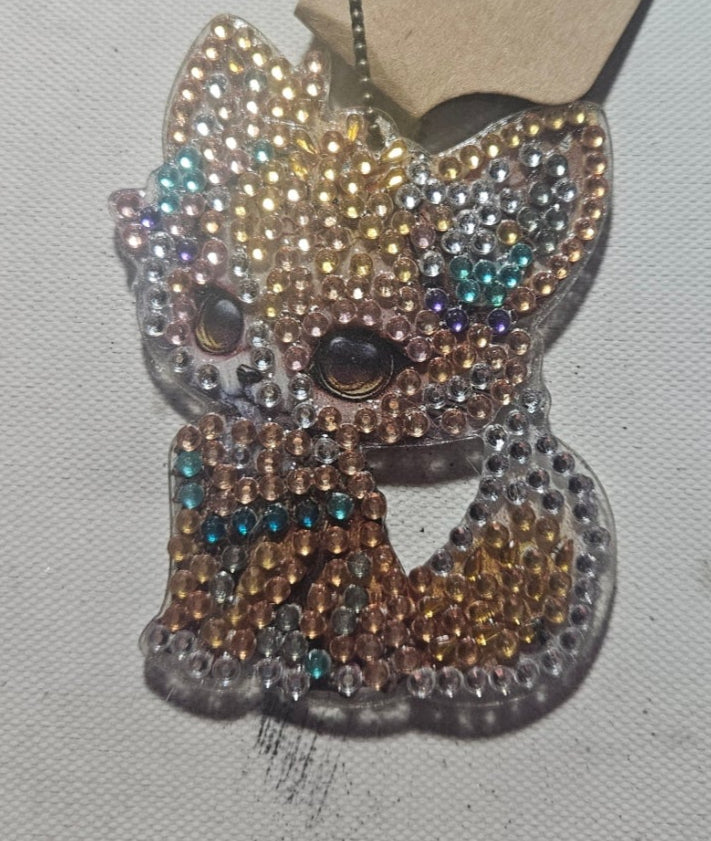 Decorative bow with rhinestones on a beige card against a light gray background