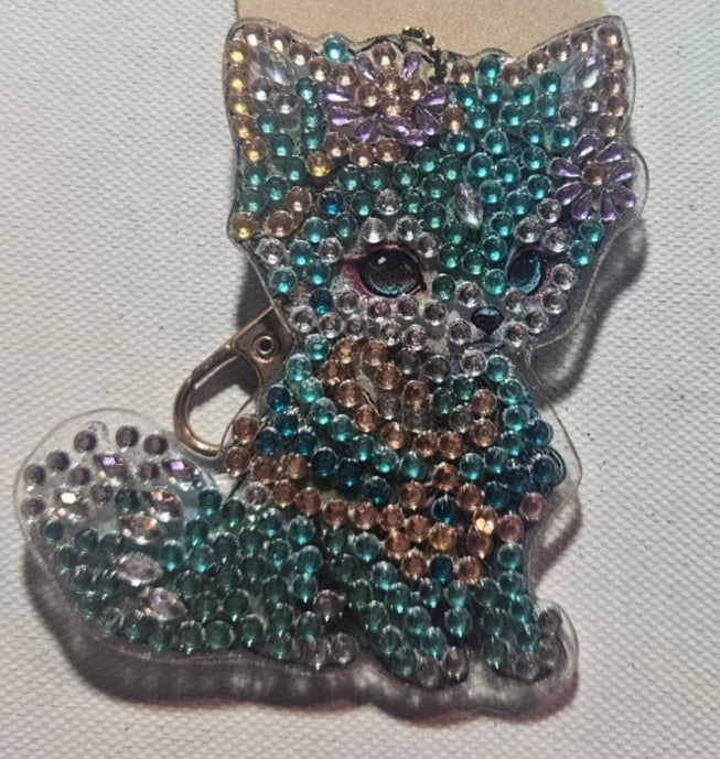 Beaded bow-shaped accessory on a cardboard backing against a plain background