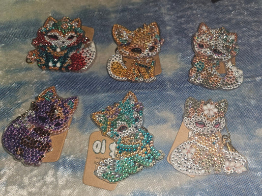Set of decorative brooches on a textured fabric background