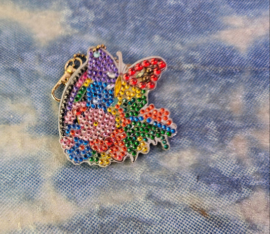 Colorful butterfly-shaped decorative item on a textured fabric background