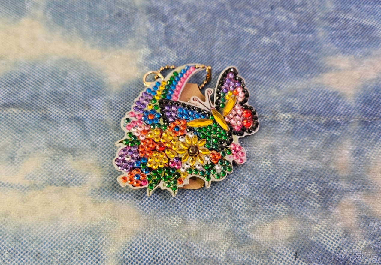 Multicolored butterfly-shaped brooch on a blue fabric background
