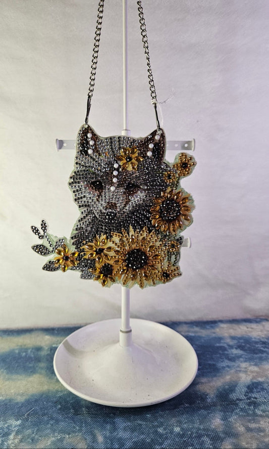 Decorative headpiece with floral design on a stand against a textured wall.