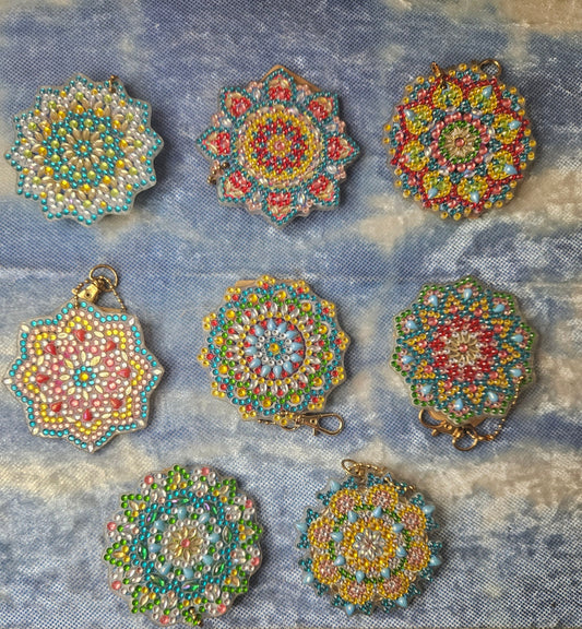 Set of colorful beaded pendants on a textured fabric background