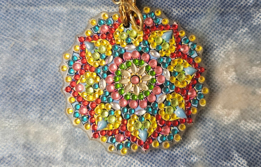 Colorful beaded keychain on a textured fabric background
