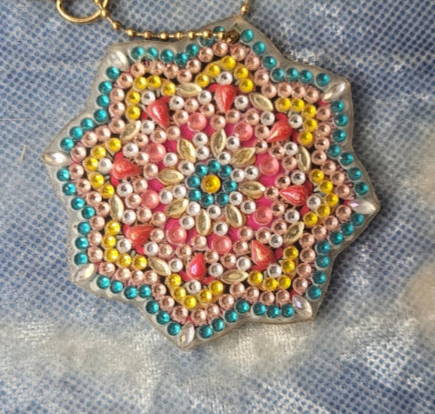 Decorative keychain with beads on a textured fabric background
