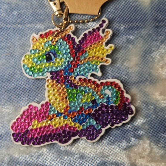 Colorful dragon-shaped keychain on a textured fabric background