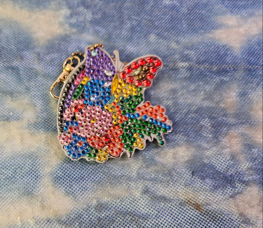 Colorful butterfly-shaped decorative item on a textured fabric background
