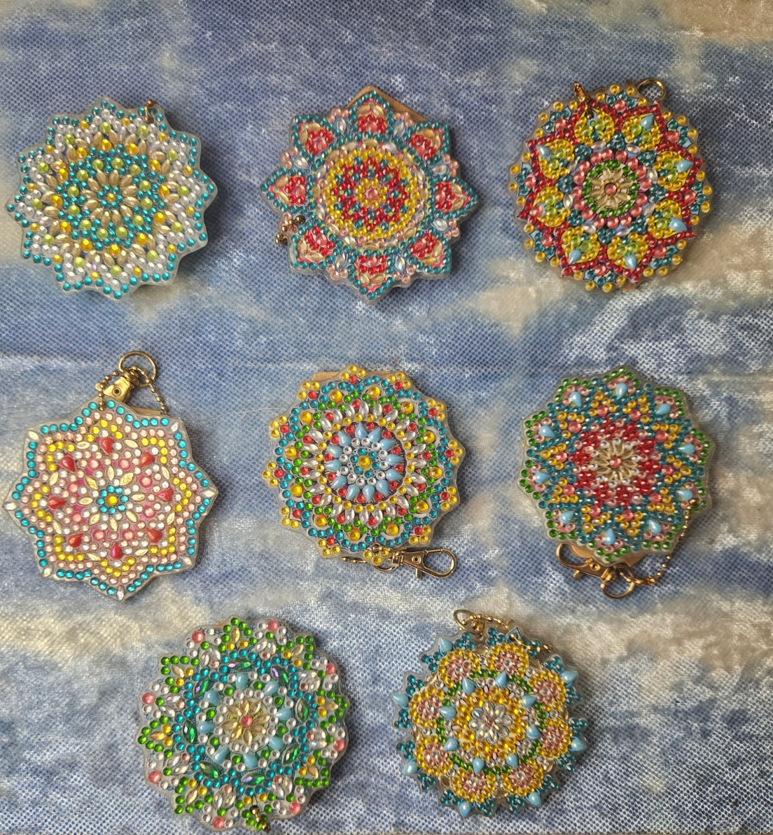 Set of colorful beaded pendants on a textured fabric background