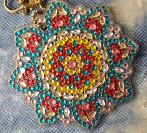 Decorative keychain with colorful pattern on a textured fabric background